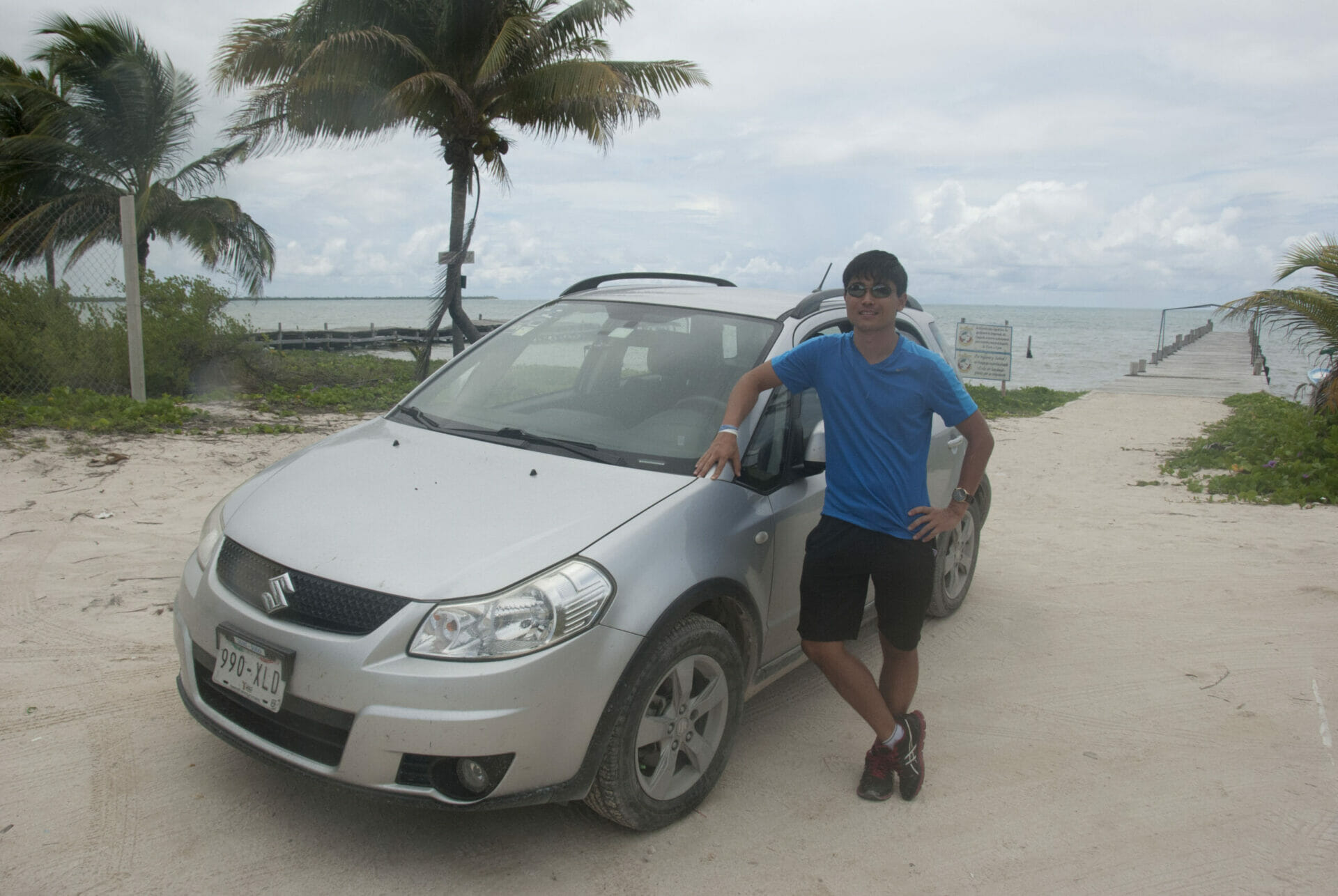 Mexican tourist guide Isao Iwasaki poses next to his car