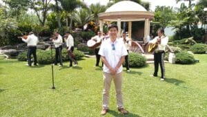 Mexican tourist guide Isao Iwasaki poses with mariachi in the background