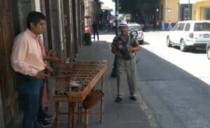 男性3人が道の歩道でマリンバを演奏している