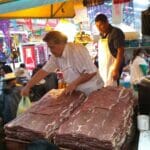 メキシコの市場で男性が肉を売っている