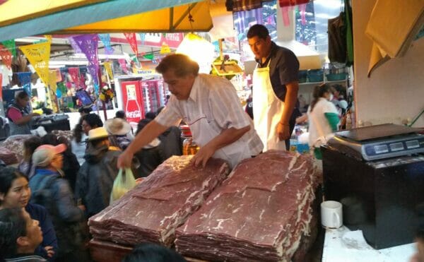 メキシコの市場で男性が肉を売っている