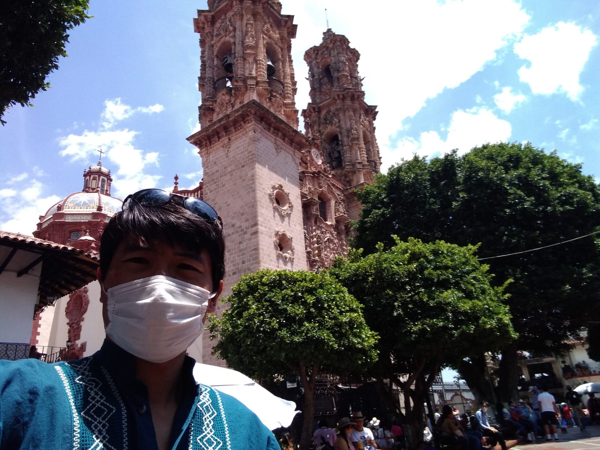 Mexico guide Isao Iwasaki wearing a mask with a church in the background