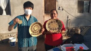 Isao Iwasaki, a Mexican guide, and a local woman have handicrafts