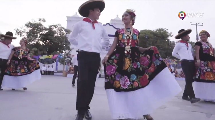 A man and a woman dancing in traditional Oaxacan costumes