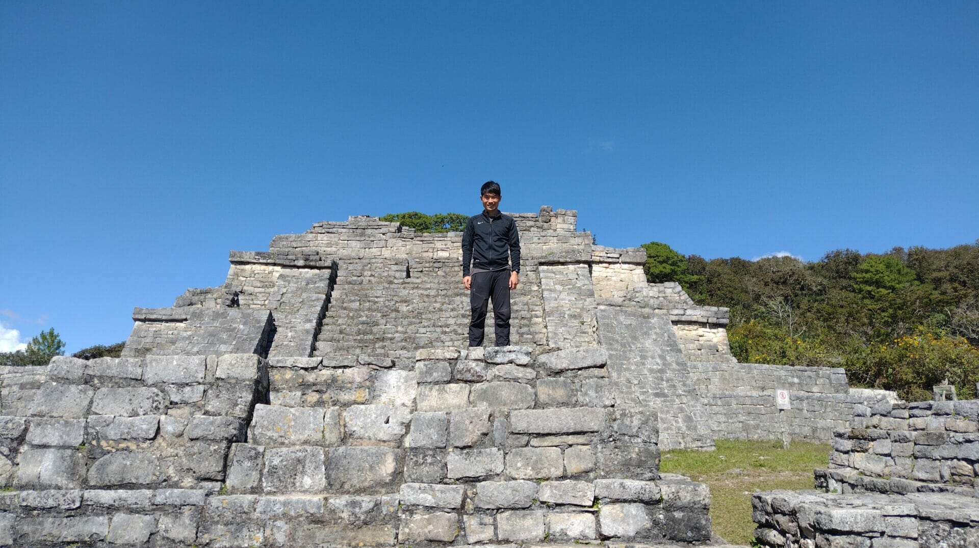 メキシコの観光ガイド岩﨑功が遺跡の上に立っている