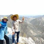 見晴らしの良い山の上でポーズをとる男性と女性