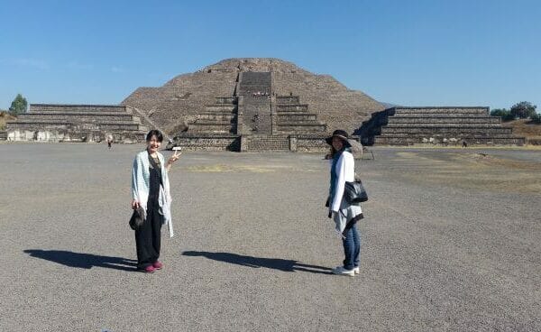 ピラミッドの前に立つ二人の女性