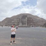 ピラミッドを背景にポーズをとる男性