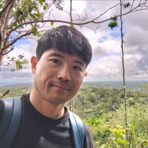 遺跡のでマヤの森をバックに自撮りしている男性