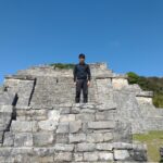 メキシコの観光ガイド岩﨑功が遺跡の上に立っている